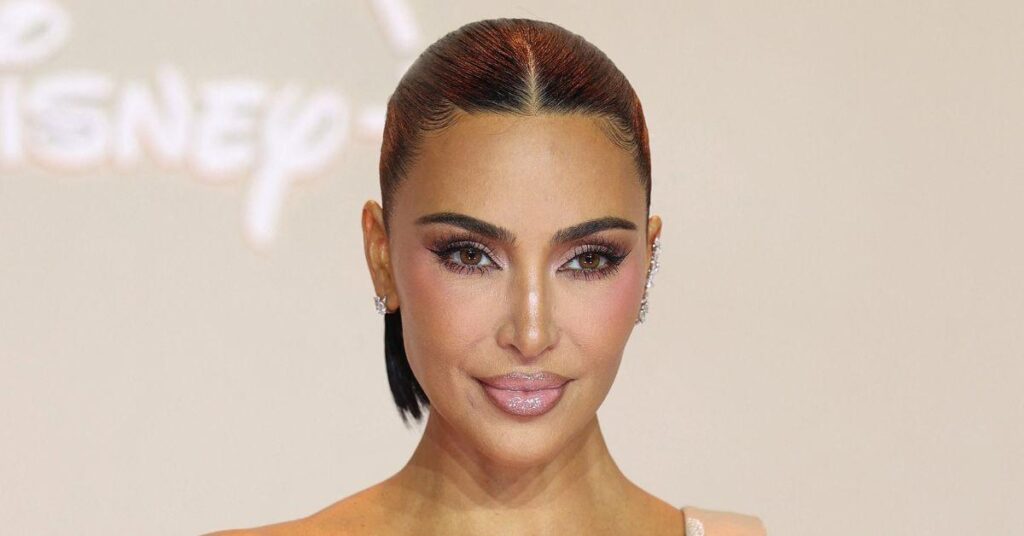 image of Kim Kardashian matched the edgy vibe in red leather pants and thigh-high boots.