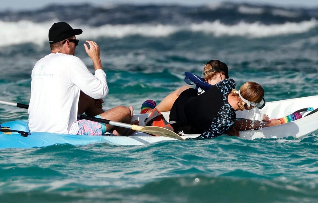 Photo of Carter Reum and Phoenix held on while Paris Hilton dunked her head into the ocean.