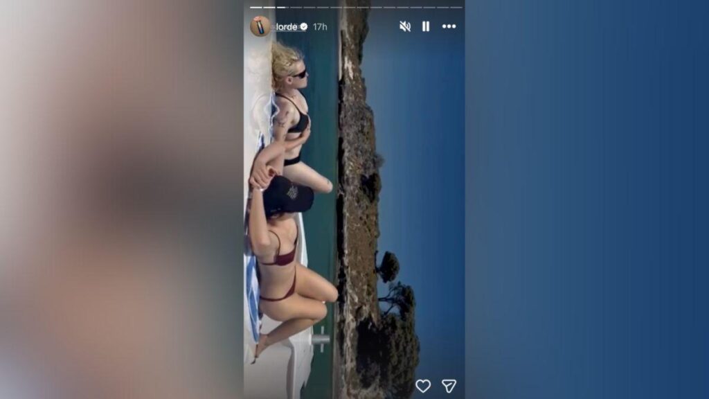 Image of Lorde tanned at the back of a boat.